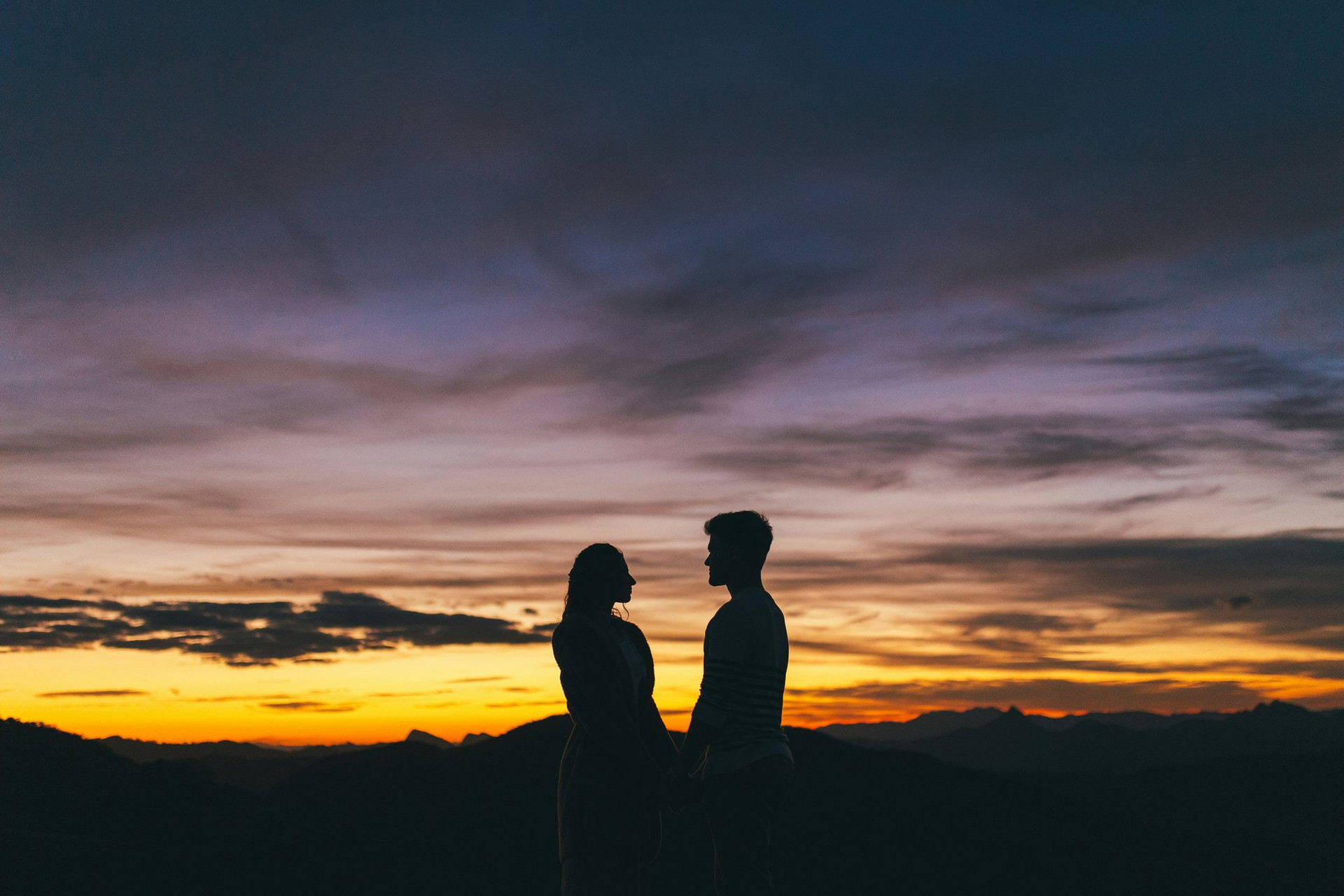 Silhouette d'un couple au coucher de soleil en montagne