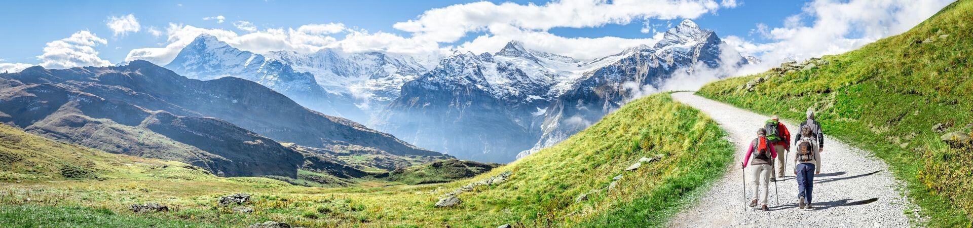 Randonneurs sur sentier face aux sommets enneigés - Alpes suisses