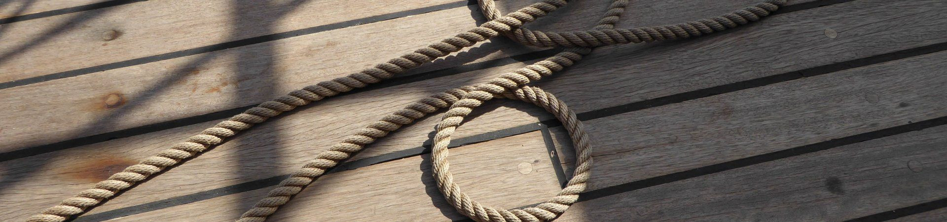Cordage lové sur le pont en bois d'un bateau - Croisière fluviale