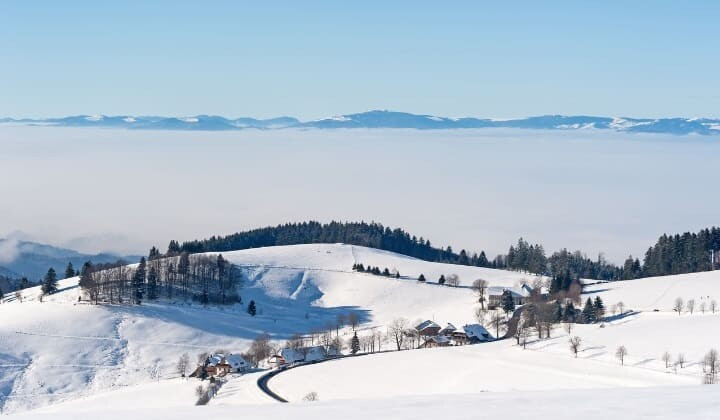 Collines enneigées au-dessus d'une mer de nuages