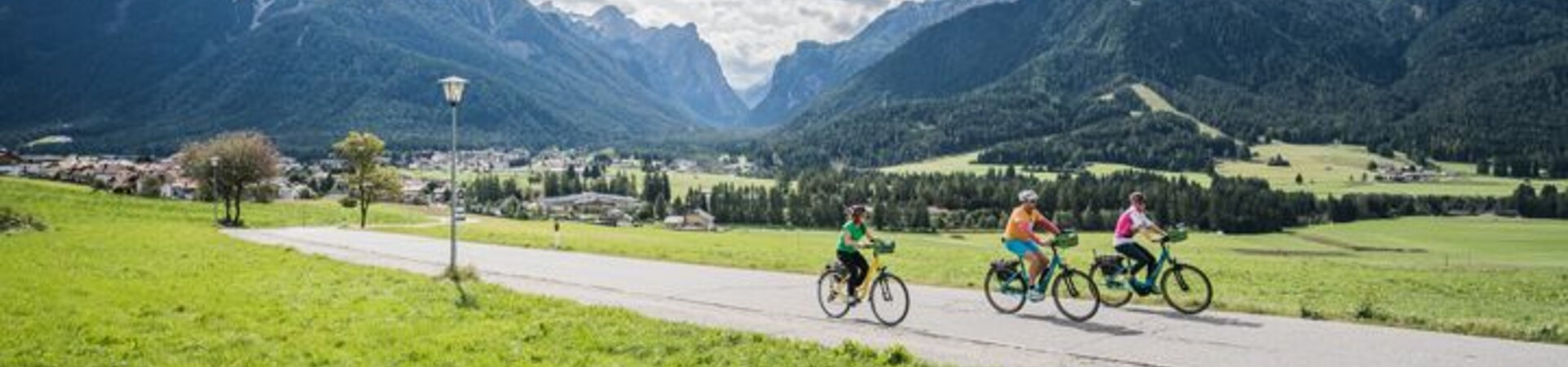 Cyclistes sur la voie verte face aux Dolomites - Munich à Venise - Italie